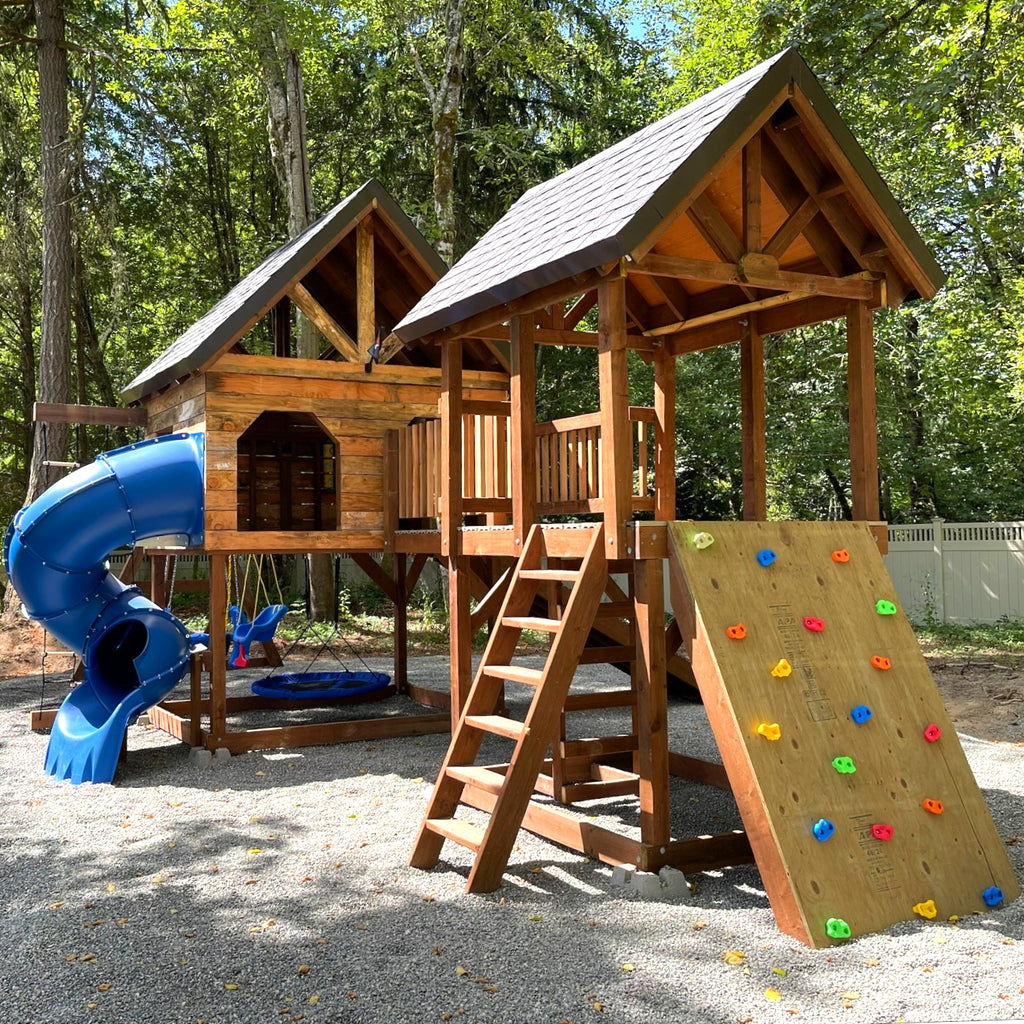 large playset with gable roofs, rock wall and spiral slide