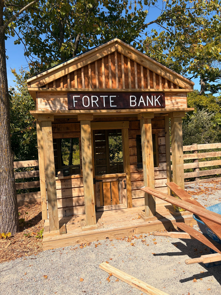 Wooden bank themed playhouse with front columns.
