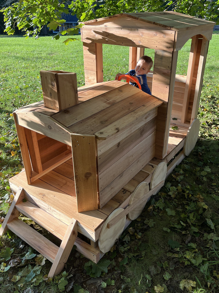 Wooden train backyard playset with small child inside