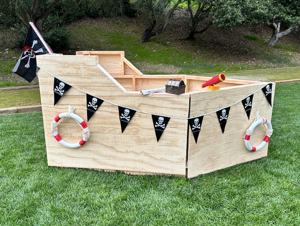 Small wooden pirate ship with pennant string crossbones.