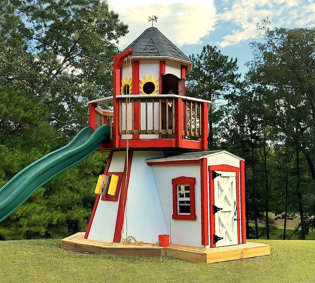 Red lighthouse playhouse with balcony and green slide in a backyard.
