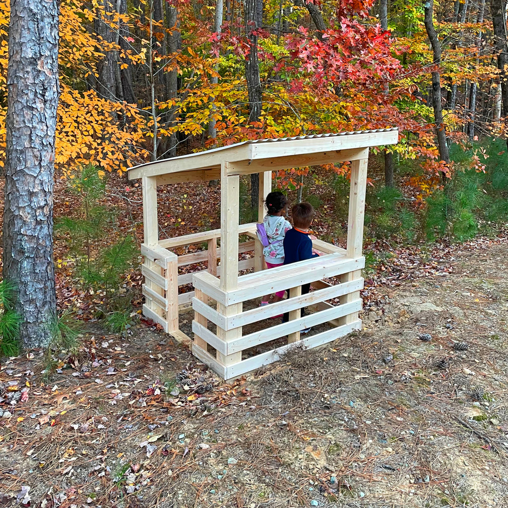 Two children inside small shed roof, open design playhouse