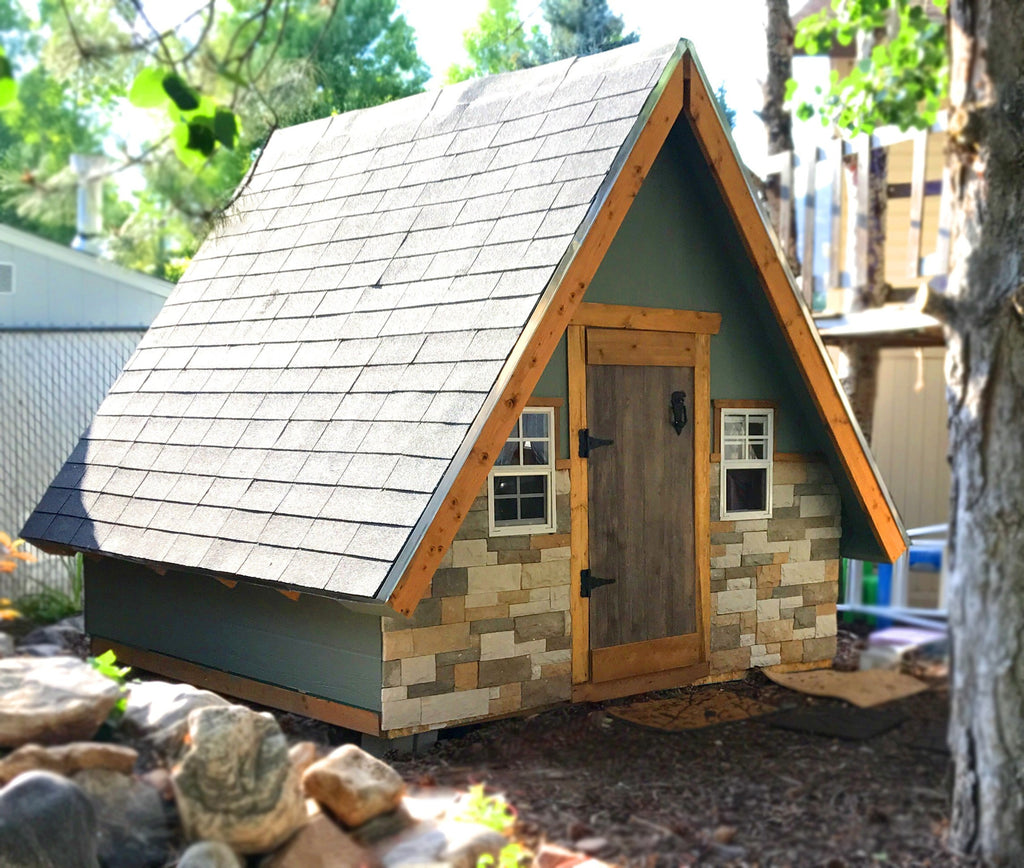 small, wooden a-frame playhouse for children with windows and stone
