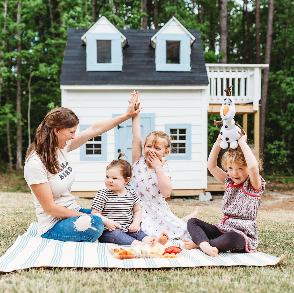Family picnic near while playhouse with balcony