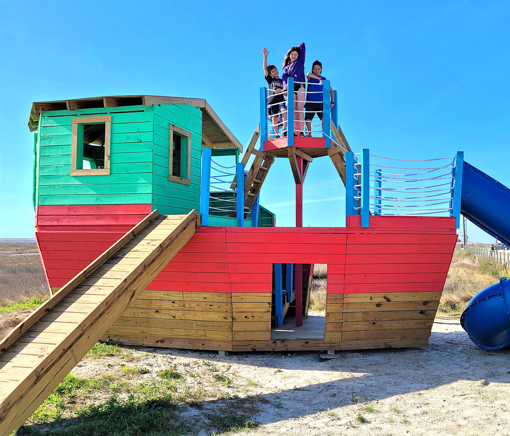 Large red and blue pirate ship with children playing in the crow's nest