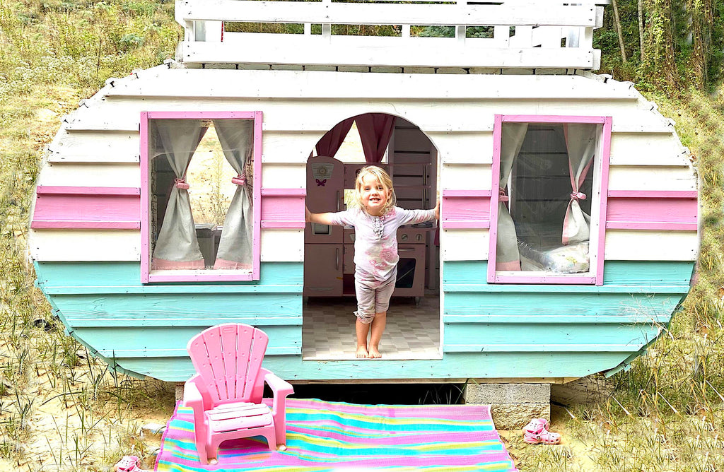 Pink and blue, wood camper playhouse with little girl