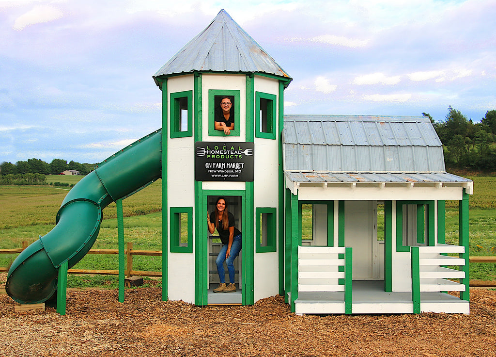Green barn and silo playhouse with a slide on a farm