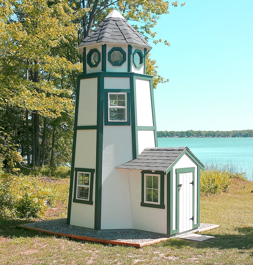 Green, 3 story lighthouse playhouse by a lake
