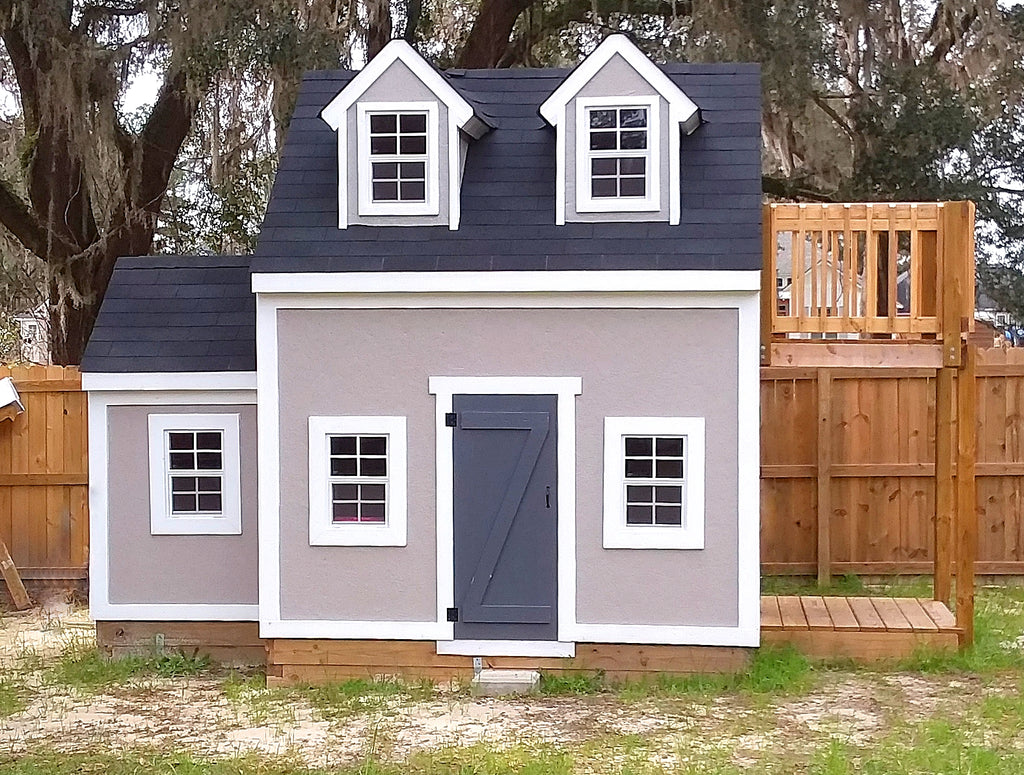 A grey painted playhouse with balcony, dormers and trim