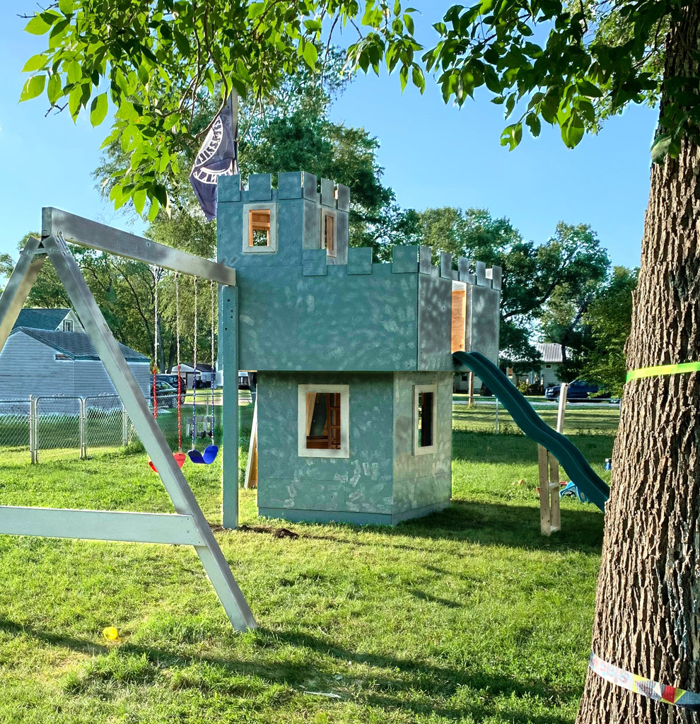 painted pentagonal castle playset with swing set in backyard