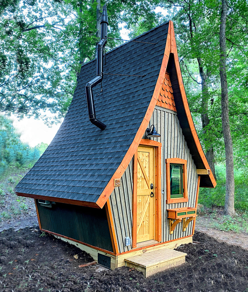 Steep curving roof playhouse with crooked stovepipe in the woods