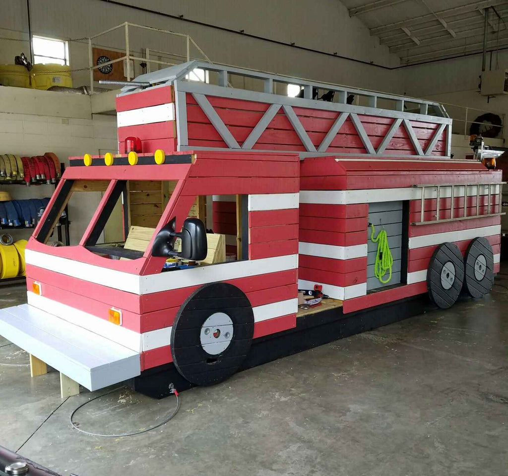 Red fire truck playset inside a firehouse