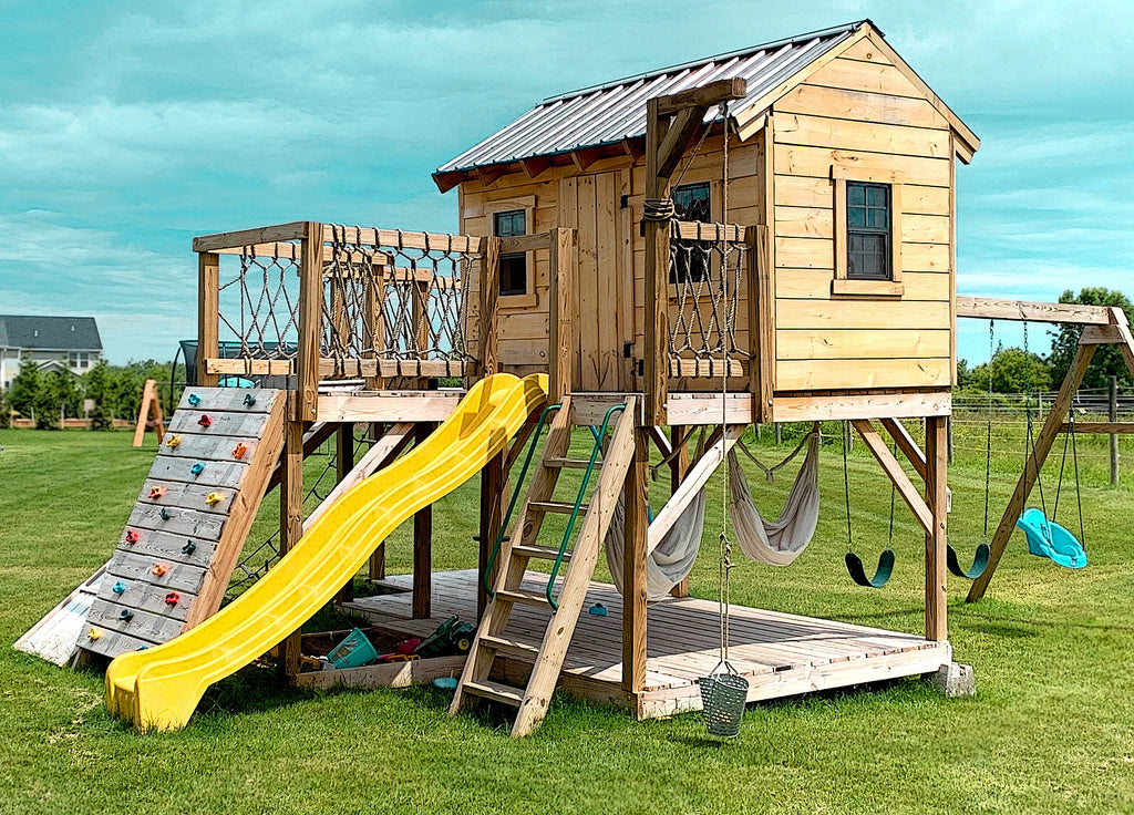 Two level playhouse with a swing-set, slide, rock wall, ladder and other accessories