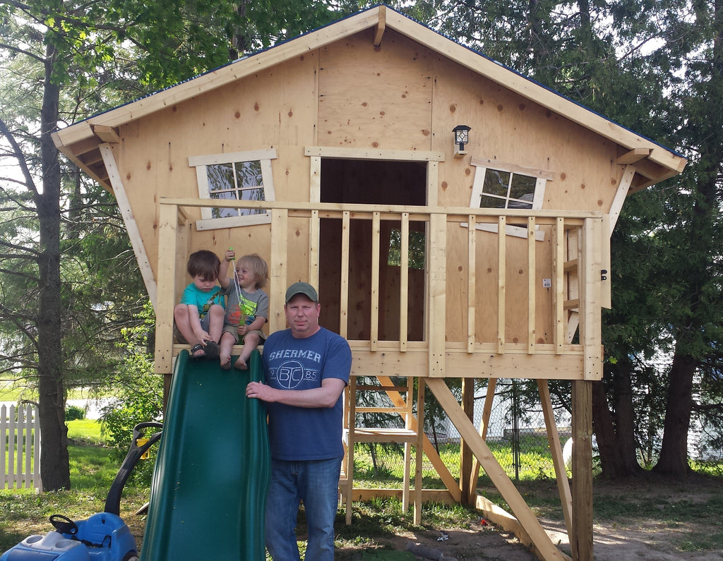father and sons outside wooden playhouse plan
