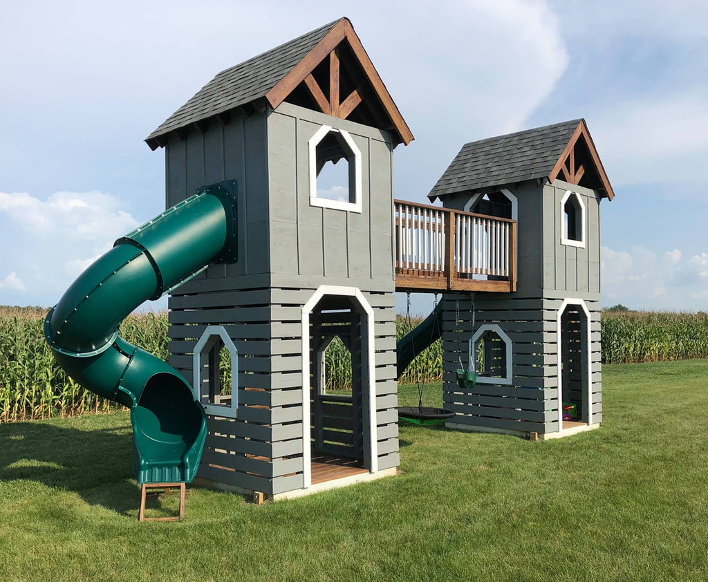 Grey, two tower playset connected by a bridge in a corn field