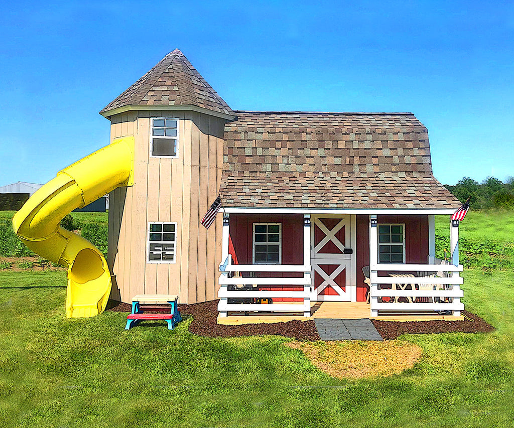 Outdoor barn and silo playhouse with yellow slide on a farm