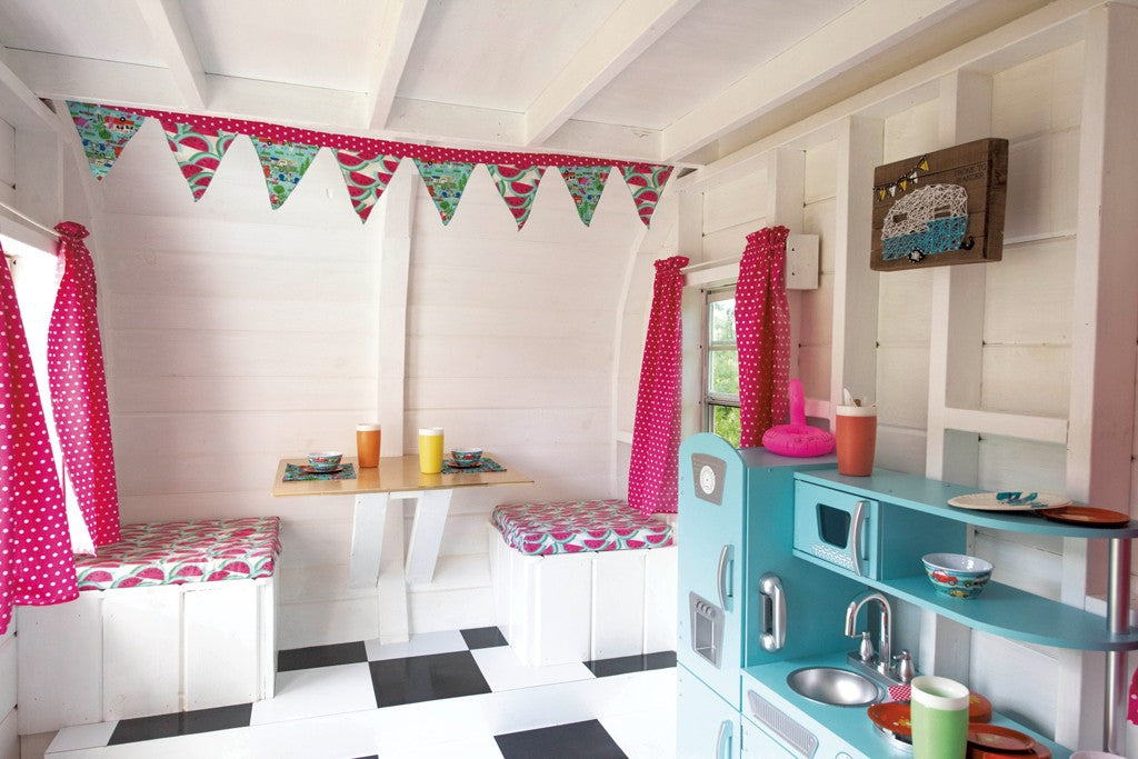 Inside the camper playhouse with a table, chairs and kitchen-set