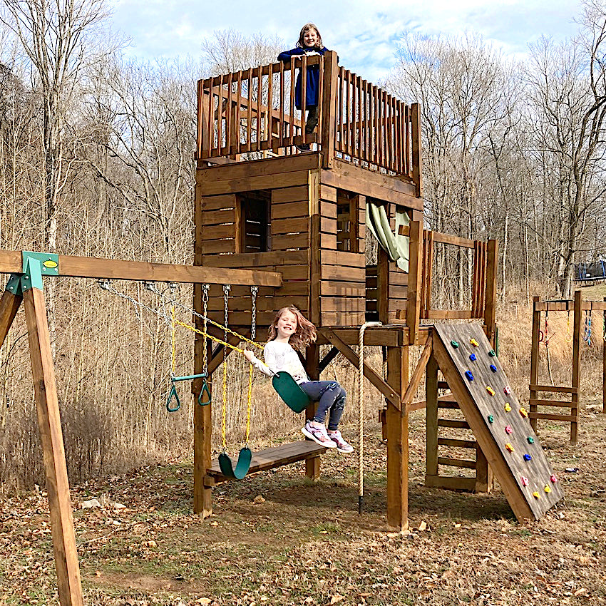 two girls playing on a 3 story DIY playset